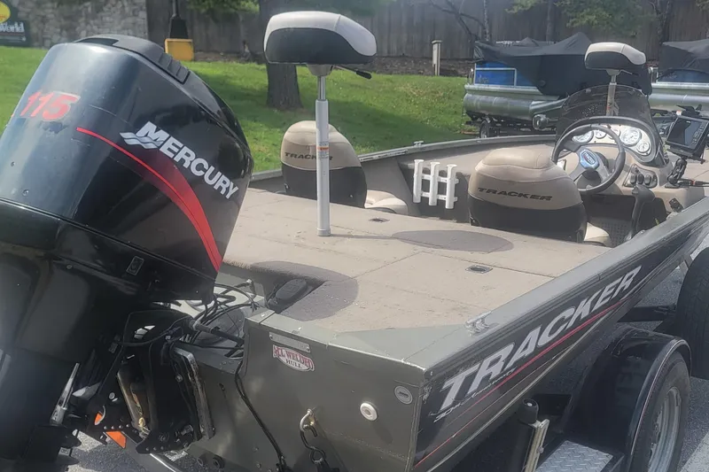 Slide: The Image of 2008 Tracker Tournament V-18 boat with Mercury 115 outboard motor, parked outdoors. - 3