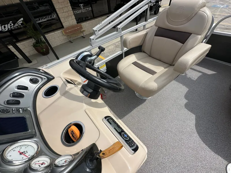 Slide: The Image of Interior of a 2017 Tracker 20 DLX boat with steering console and seat. - 21