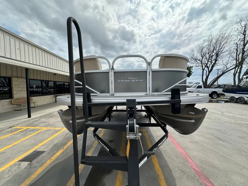 Slide: The Image of 2017 Tracker 20 DLX pontoon boat on trailer in front of building. - 8