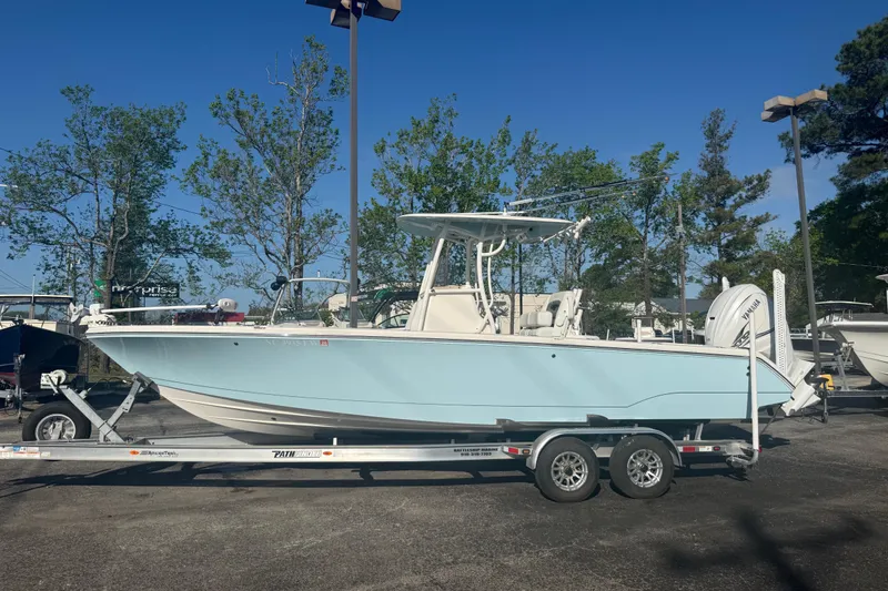 The Image of 2022 Pathfinder 2700 Open boat on trailer, light blue hull, parked outdoors. - 1