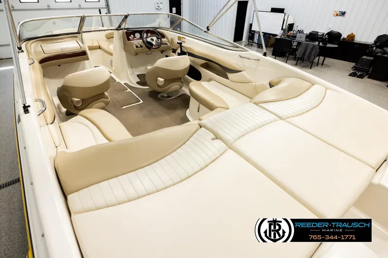 Slide: The Image of 2006 Glastron GX 235 boat interior with beige seating and steering console. - 11
