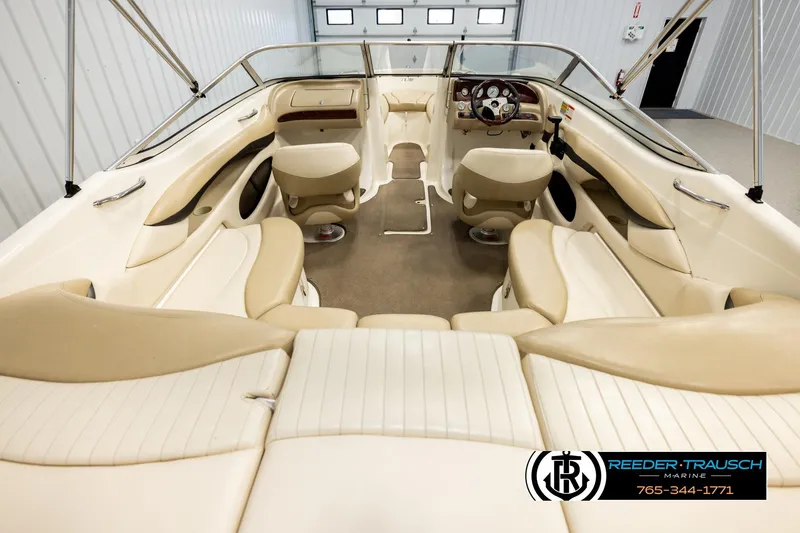 Slide: The Image of Interior view of a 2006 Glastron GX 235 boat with beige seating and steering console. - 13