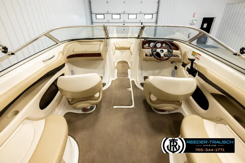 Slide: The Image of 2006 Glastron GX 235 boat interior with beige seating and steering console. - 14