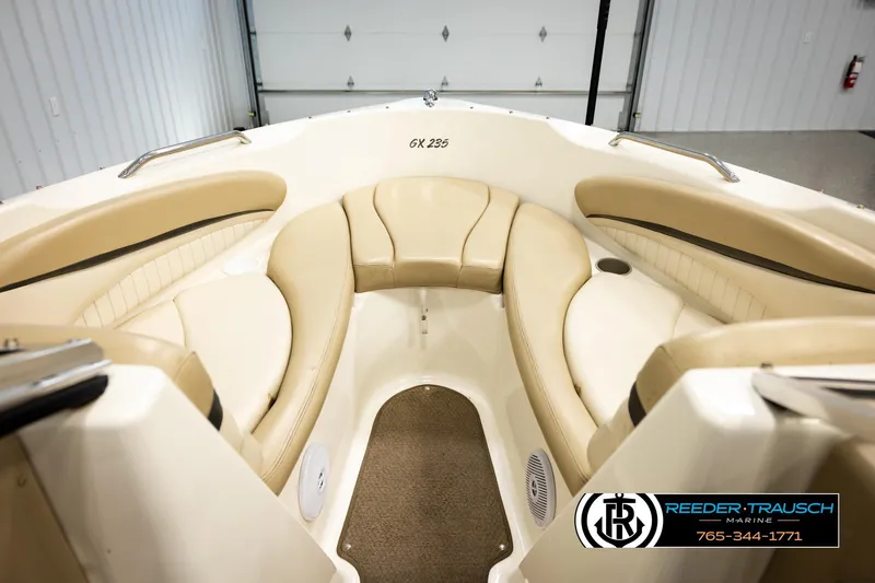 Slide: The Image of 2006 Glastron GX 235 boat interior with beige seating and carpeted floor. - 24