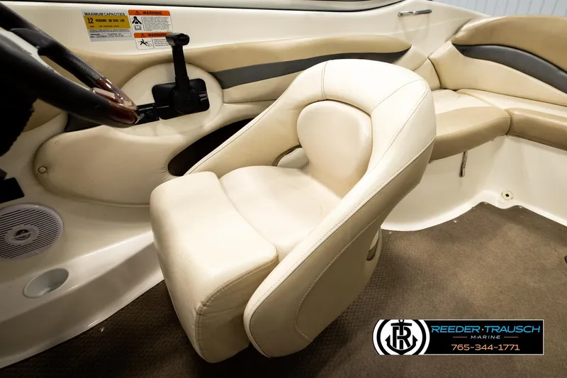 Slide: The Image of 2006 Glastron GX 235 boat interior with beige seating and steering wheel. - 26