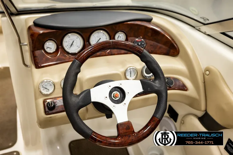 Slide: The Image of 2006 Glastron GX 235 boat dashboard with wood accents and steering wheel. - 29
