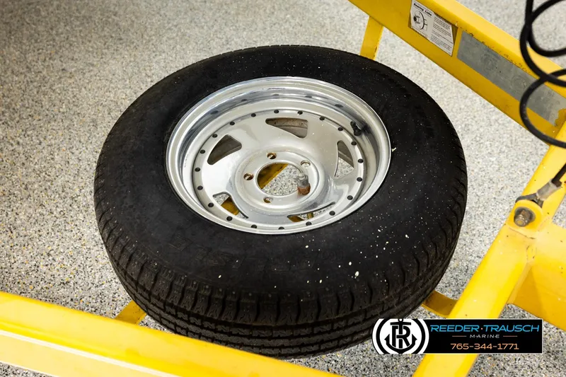 Slide: The Image of Tire and rim on a yellow lift, related to 2006 Glastron GX 235 boat. - 47