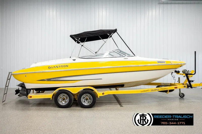 Slide: The Image of 2006 Glastron GX 235 boat with yellow accents on a matching trailer. - 5
