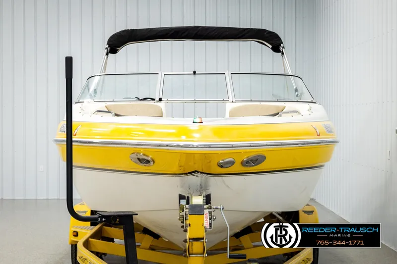 Slide: The Image of 2006 Glastron GX 235 boat with yellow hull on trailer in indoor storage. - 8