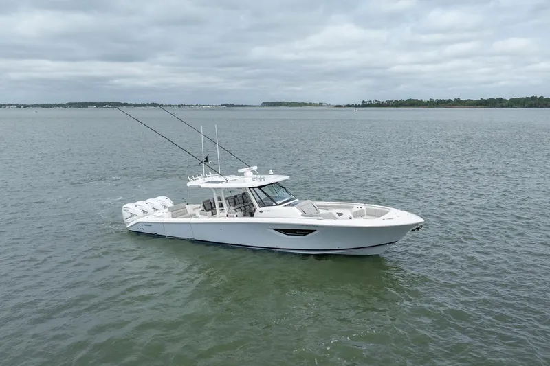 Slide: The Image of 2023 Pursuit S 428 Sport boat cruising on open water under cloudy skies. - 3
