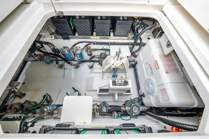 Slide: The Image of Engine compartment of 2023 Pursuit S 428 Sport boat, showcasing batteries and mechanical components. - 38