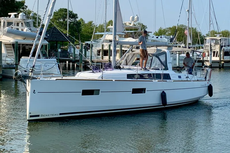 The Image of 2016 Beneteau Oceanis 38.1 sailboat docked in a marina with people on board. - 0