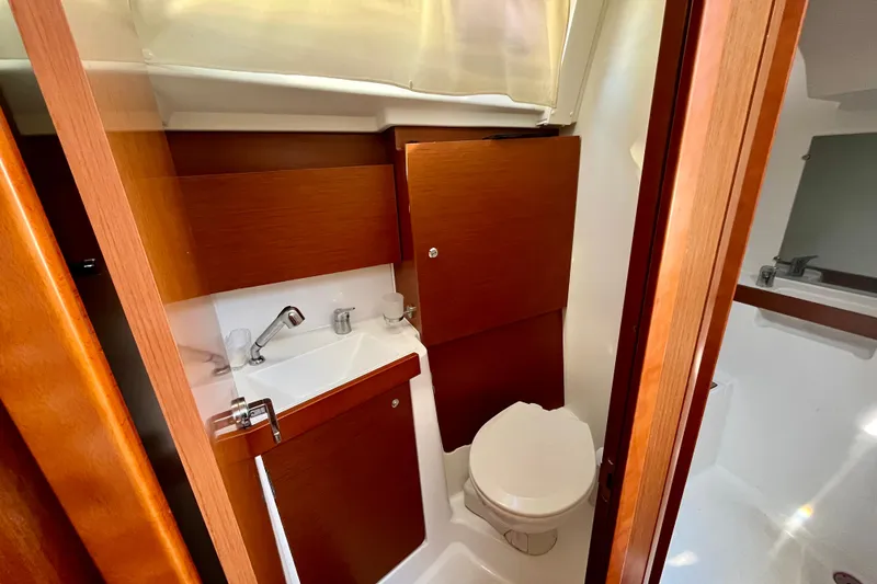 Slide: The Image of Interior view of 2016 Beneteau Oceanis 38.1 yacht bathroom with wooden cabinetry. - 12