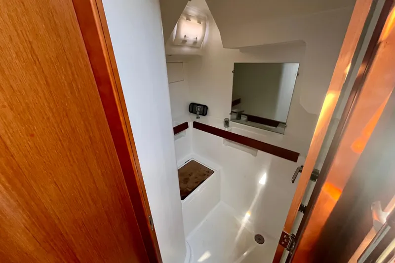 Slide: The Image of Interior of 2016 Beneteau Oceanis 38.1 yacht bathroom with wooden accents and mirror. - 13