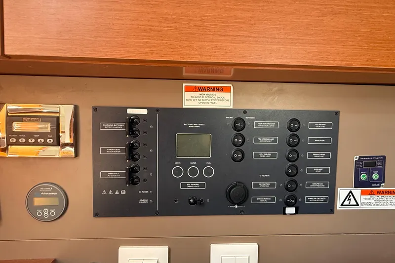 Slide: The Image of Control panel of a 2016 Beneteau Oceanis 38.1 sailboat with various switches and warnings. - 23