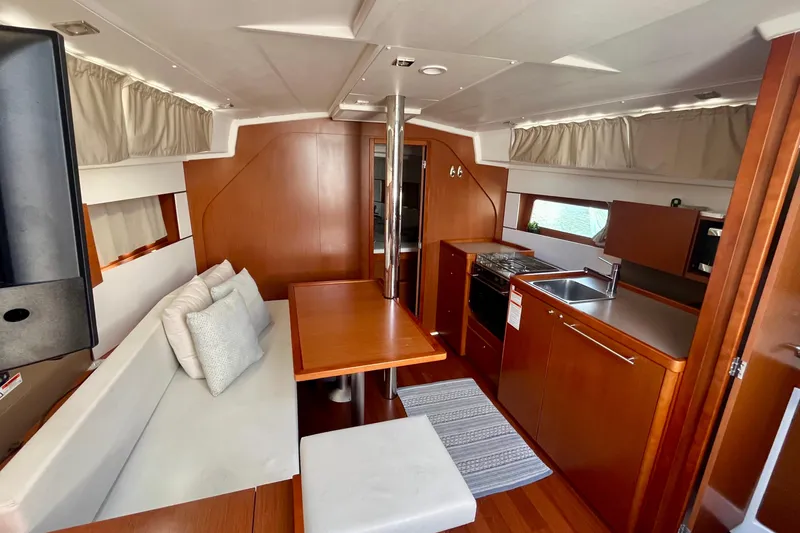 Slide: The Image of Interior of 2016 Beneteau Oceanis 38.1 yacht with modern kitchen and cozy seating area. - 6