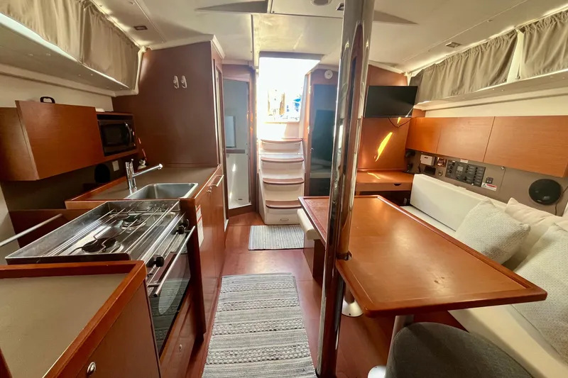 Slide: The Image of Interior of 2016 Beneteau Oceanis 38.1 yacht with kitchen and dining area. - 7