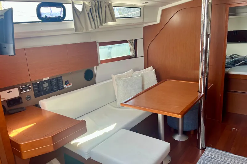 Slide: The Image of Interior of 2016 Beneteau Oceanis 38.1 yacht with cozy seating and wooden table. - 9