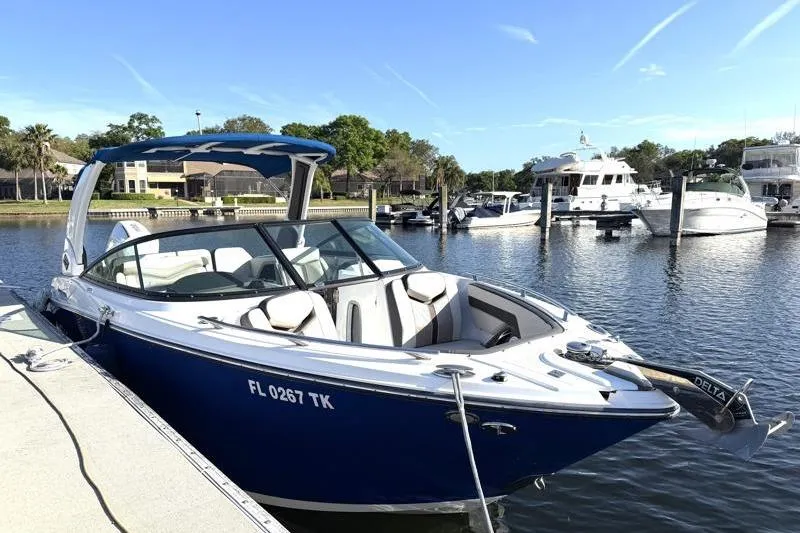 Slide: The Image of 2022 Monterey 255SS Super Sport boat docked in a marina under clear blue skies. - 2