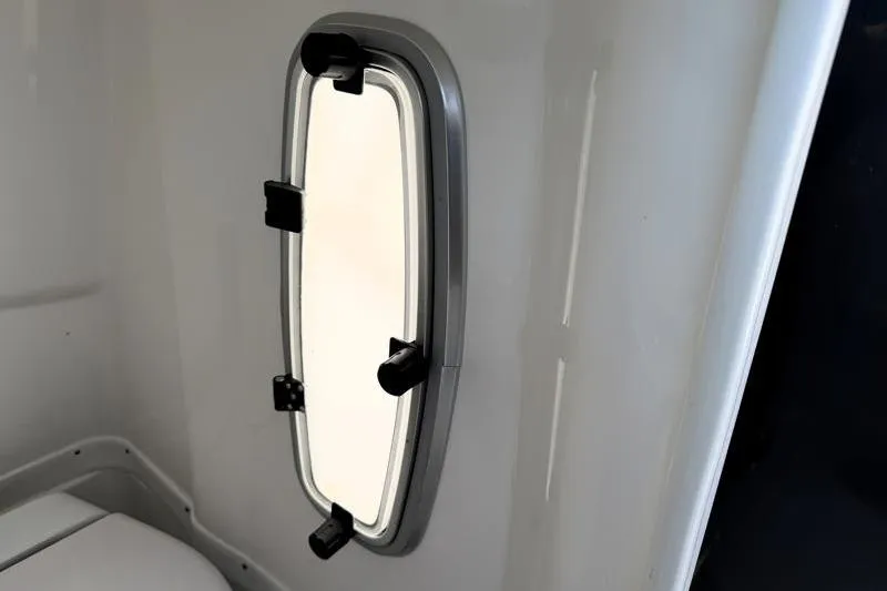 Slide: The Image of Oval window inside 2022 Monterey 255SS Super Sport boat cabin. - 22