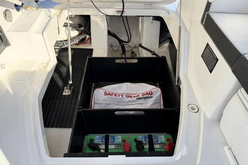 Slide: The Image of 2022 Monterey 255SS Super Sport boat storage area with safety gear bag and batteries. - 47