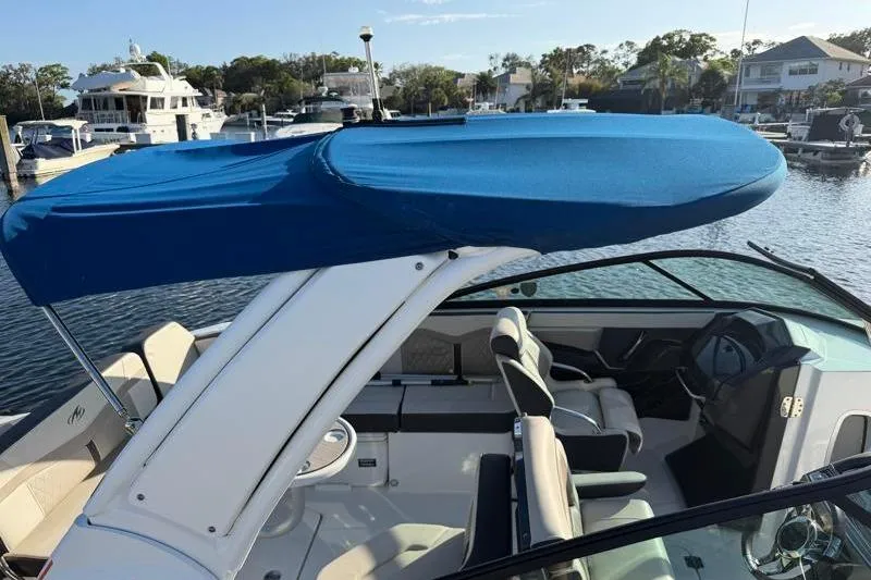 Slide: The Image of 2022 Monterey 255SS Super Sport boat with blue canopy in marina setting. - 53
