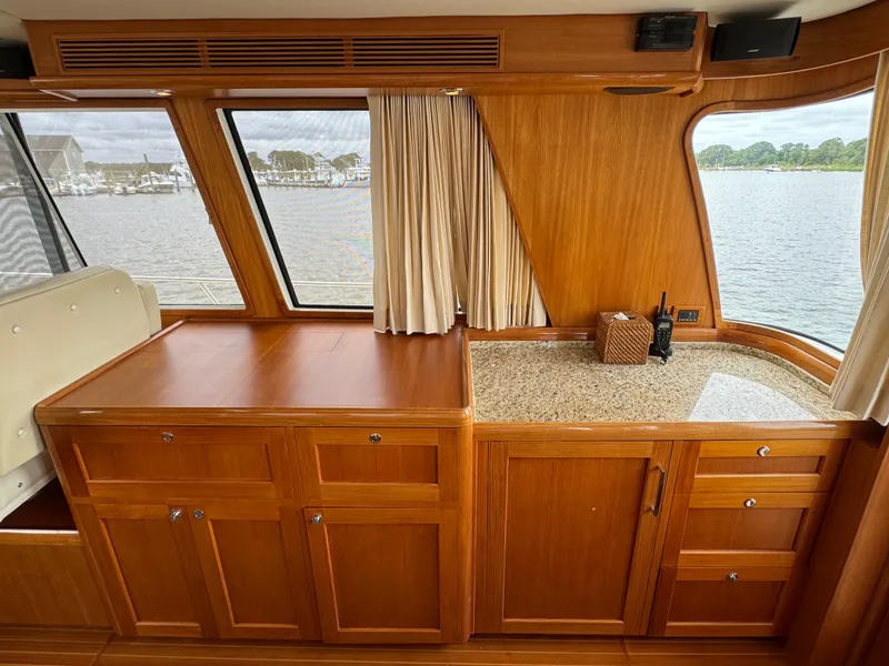 Slide: The Image of 2009 Grand Banks 45 Eastbay SX interior with wooden cabinetry and waterfront view. - 17
