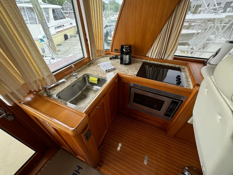 Slide: The Image of Luxurious 2009 Grand Banks 45 Eastbay SX yacht kitchen with modern amenities and wood finish. - 22