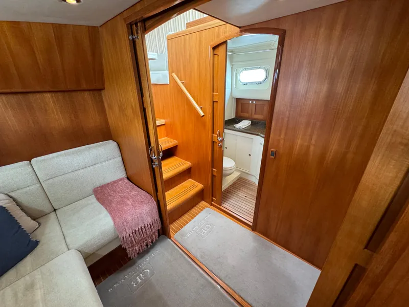 Slide: The Image of 2009 Grand Banks 45 Eastbay SX interior with wooden finish, cozy seating, and bathroom access. - 36