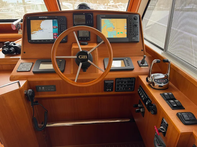 Slide: The Image of 2009 Grand Banks 45 Eastbay SX helm with navigation screens and wooden steering wheel. - 7