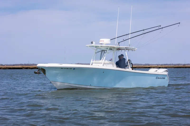 Slide: The Image of 2023 Sailfish 290 CC boat cruising on calm waters under a clear sky. - 1