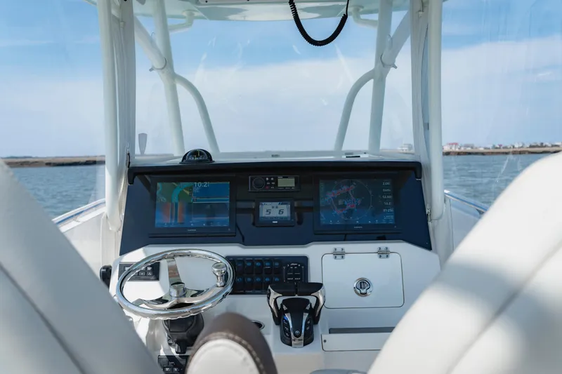 Slide: The Image of 2023 Sailfish 290 CC boat dashboard with modern navigation displays and steering wheel. - 12