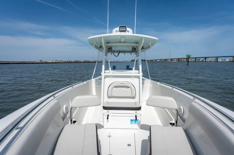 Slide: The Image of 2023 Sailfish 290 CC boat on water, showcasing spacious deck and seating. - 17