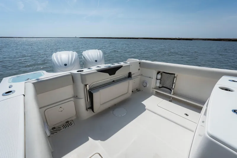 Slide: The Image of 2023 Sailfish 290 CC boat interior with dual engines, spacious deck, and ocean view. - 19