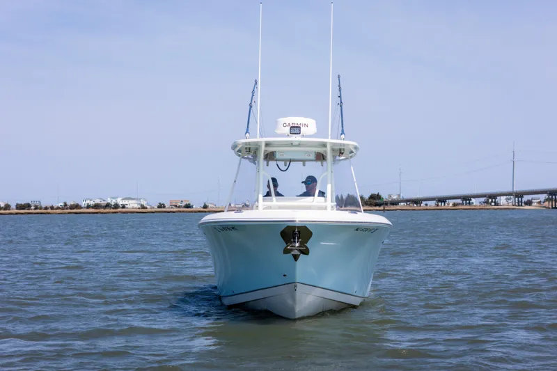 Slide: The Image of 2023 Sailfish 290 CC boat cruising on calm waters, front view. - 2