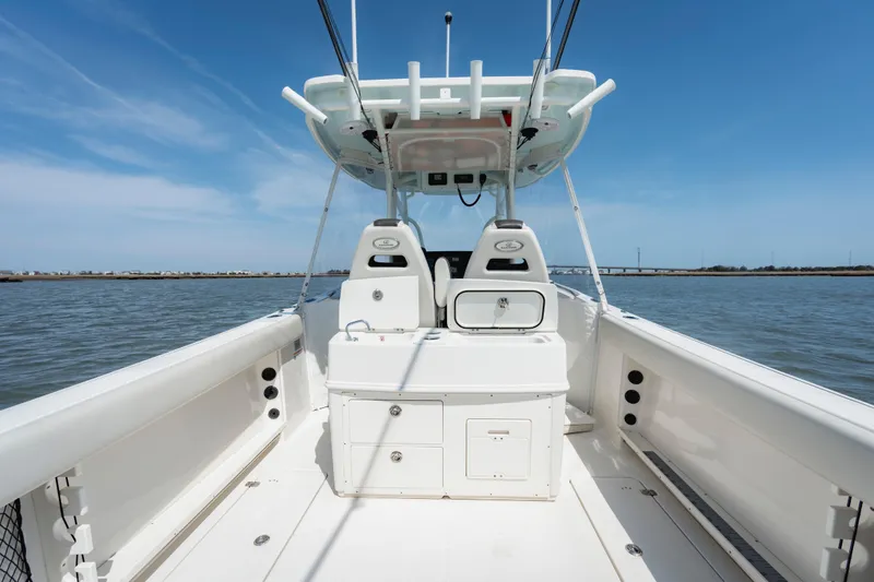 Slide: The Image of 2023 Sailfish 290 CC boat interior with helm station on calm water. - 20