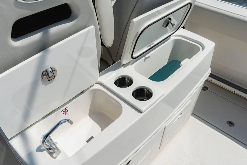 Slide: The Image of 2023 Sailfish 290 CC boat interior with sink, storage, and cup holders. - 21