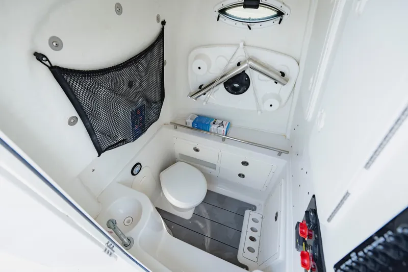 Slide: The Image of 2023 Sailfish 290 CC boat interior with compact bathroom and storage features. - 22