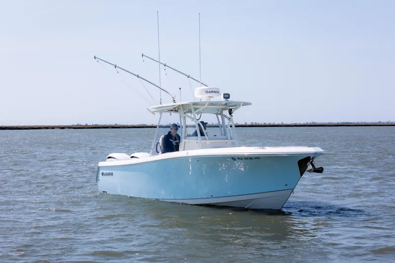 Slide: The Image of 2023 Sailfish 290 CC boat cruising on calm waters under a clear sky. - 3