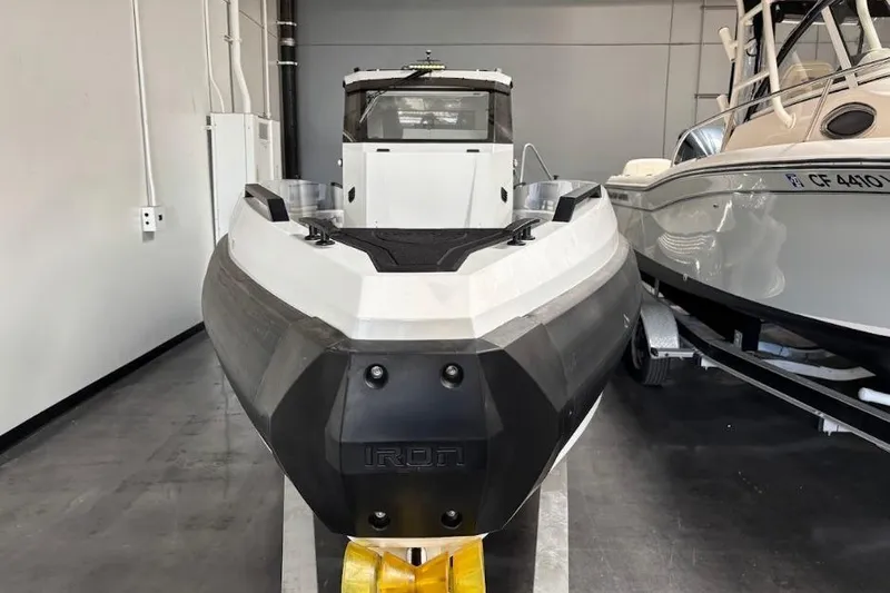 Slide: The Image of 2026 Iron 907 Coupe boat in showroom, front view, alongside another vessel. - 5