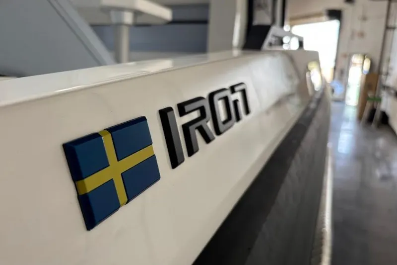 Slide: The Image of 2026 Iron 907 Coupe with Swedish flag emblem in a showroom. - 9
