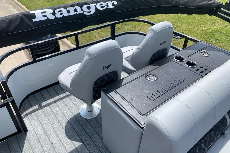 Slide: The Image of 2026 Ranger 223FC boat interior with seating and console, featuring cup holders and measuring guide. - 17