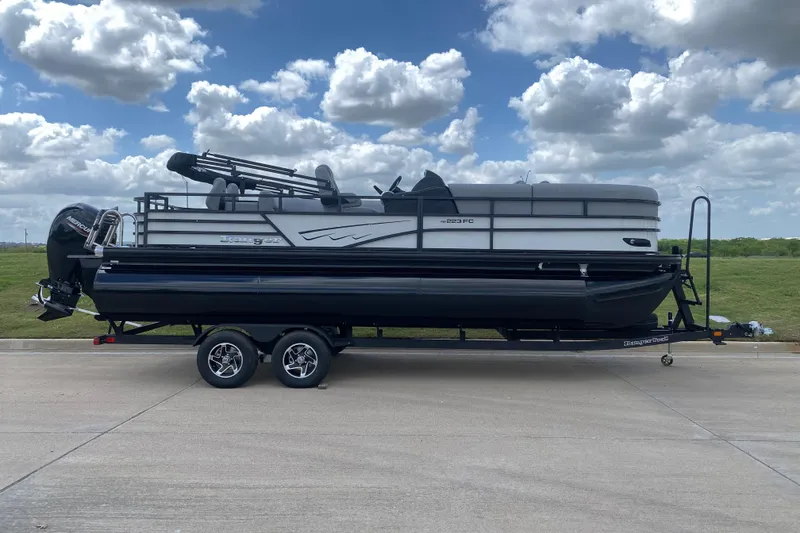 Slide: The Image of 2026 Ranger 223FC pontoon boat with red and black design on trailer. - 3