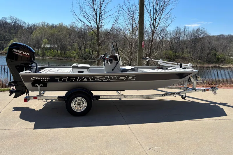 The Image of 2026 Tracker Bass Tracker Classic CC boat on trailer by a lake. - 0