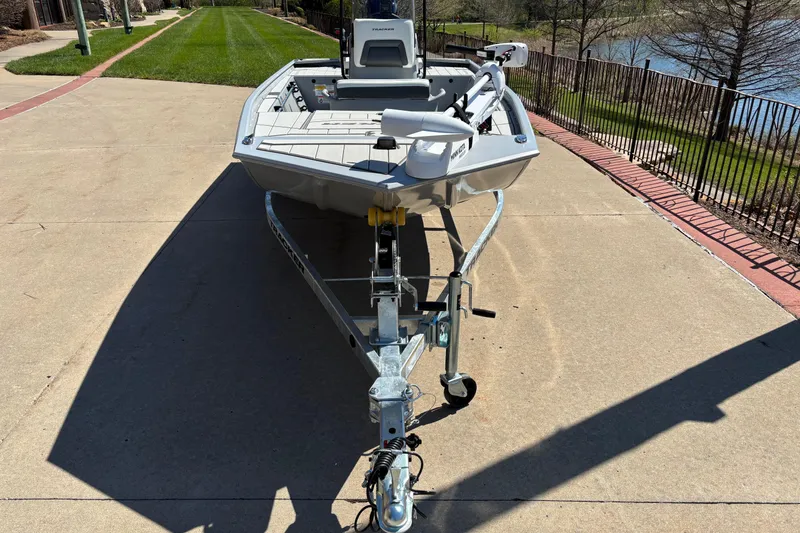 Slide: The Image of 2026 Tracker Bass Tracker Classic CC boat on trailer, parked on driveway near lake. - 2