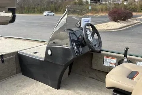 Slide: The Image of 2026 Tracker Bass Tracker Classic Limited boat console with steering wheel in a parking lot. - 11