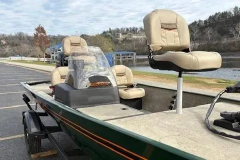 Slide: The Image of 2026 Tracker Bass Tracker Classic Limited boat with beige seats by a lakeside. - 4