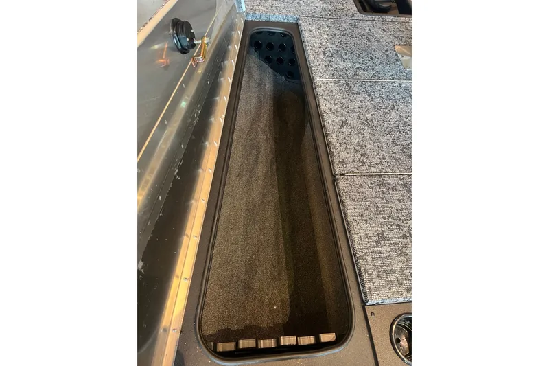 Slide: The Image of 2026 Tracker Pro Team 195 boat interior storage compartment with carpeted finish. - 13