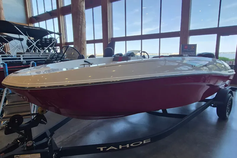 Slide: The Image of 2026 Tahoe T18 boat displayed indoors on a trailer, with large windows in the background. - 3