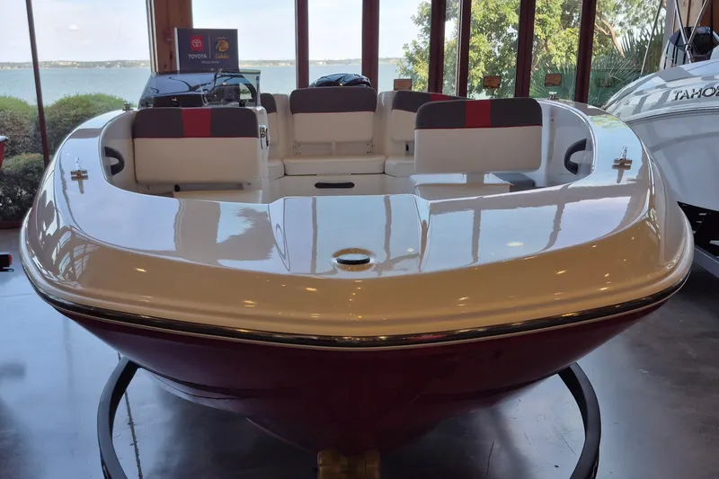 Slide: The Image of 2026 Tahoe T18 boat displayed indoors with lake view background. - 2